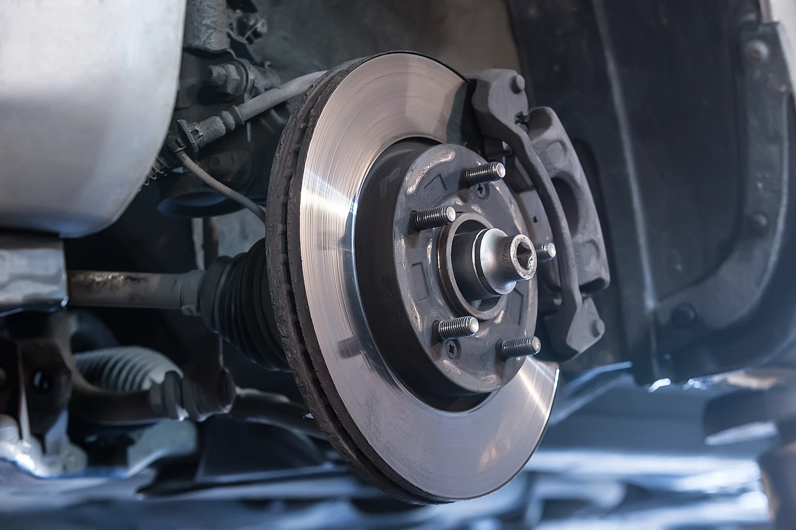Auto Tech West technician replaces brake pads on vehicle